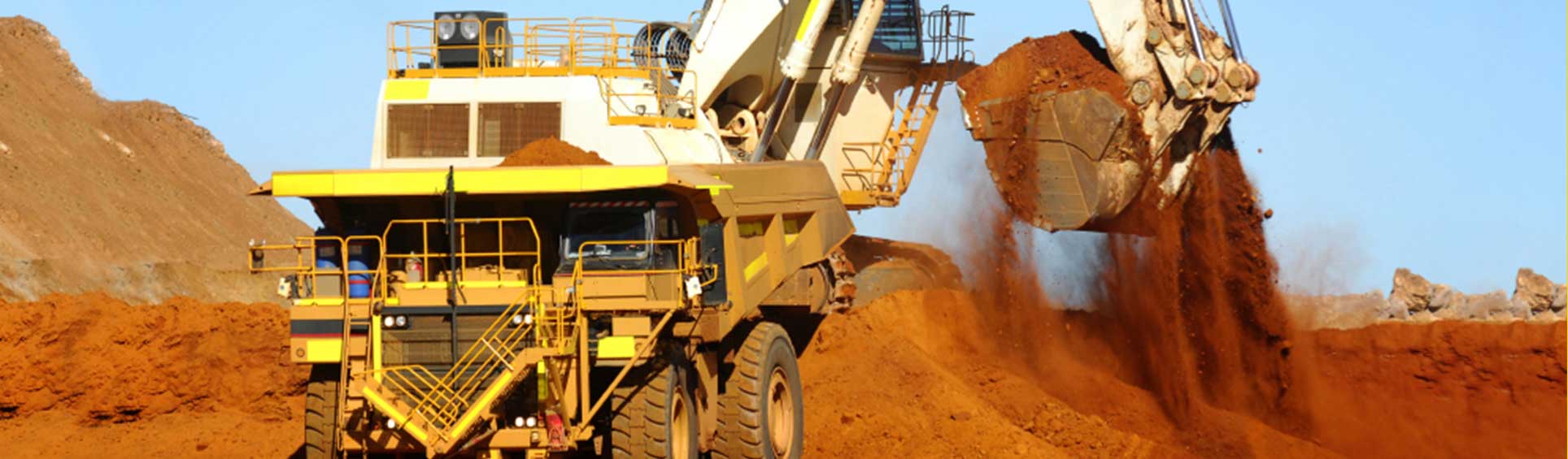 Big truck being loaded with red dirt